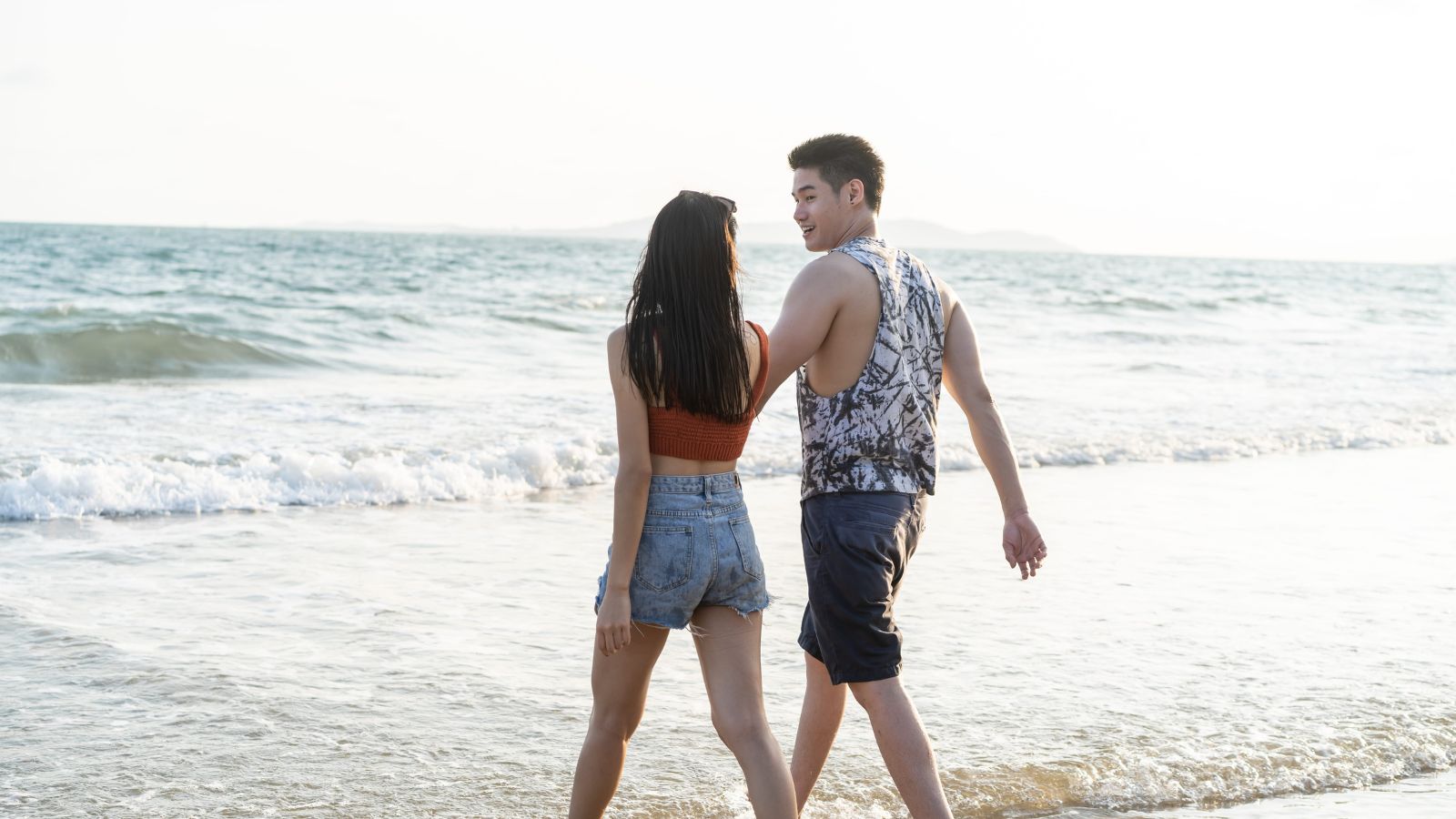 A photo of romantic couple enjoying quiet walk by beach or countryside relaxed travel peaceful environment connection slow travel lifestyle natural light candid.