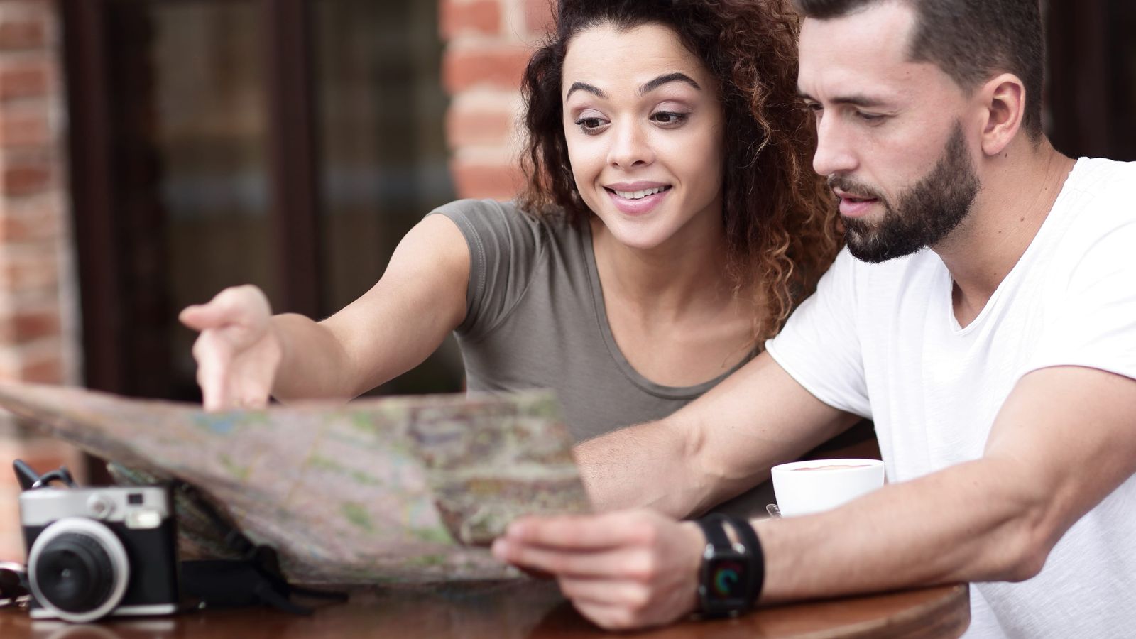 A photo of couple talking about something, looking at the map.