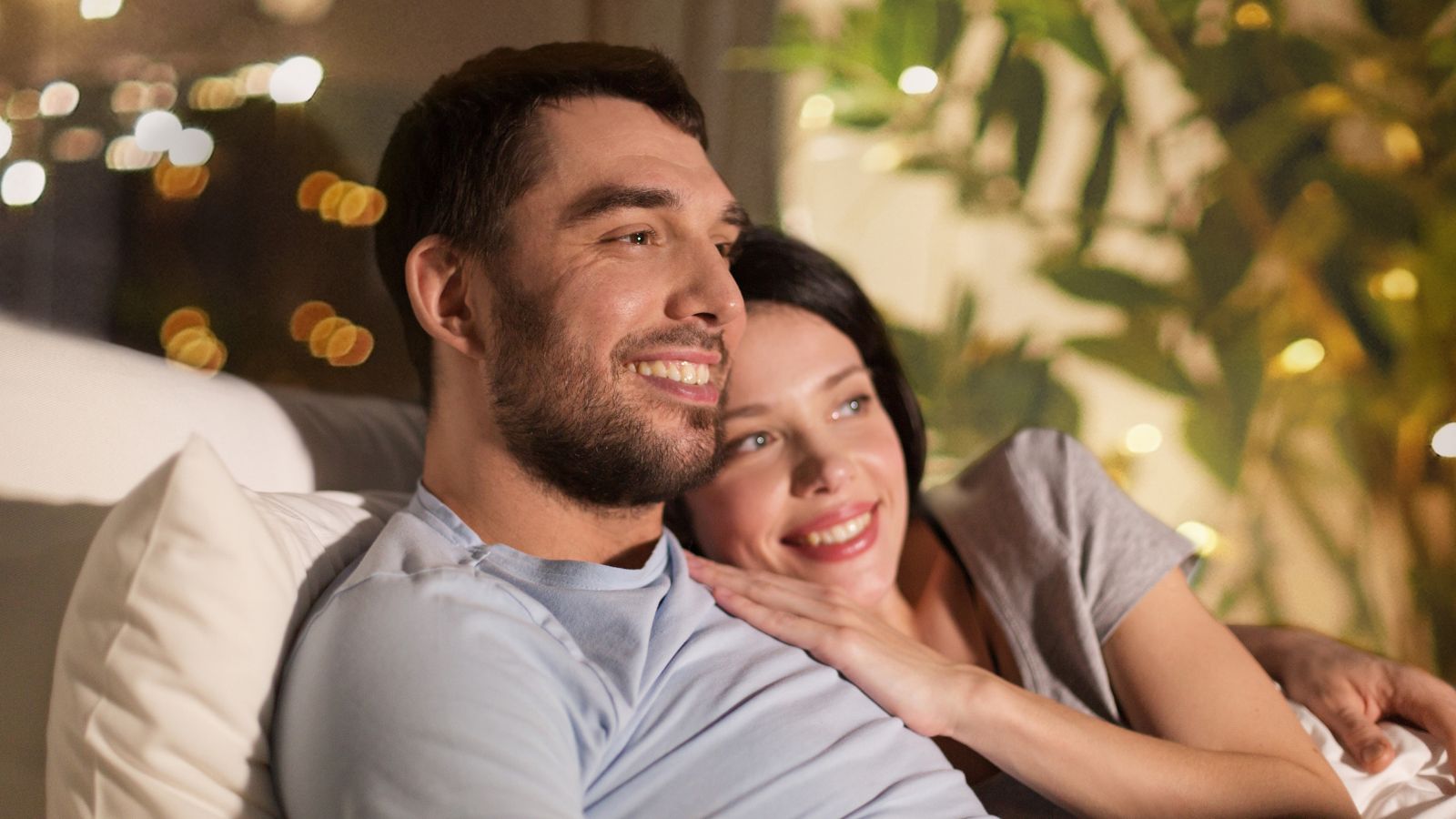 A photo of couple relaxing peacefully in quiet corner hotel room warm evening lighting.