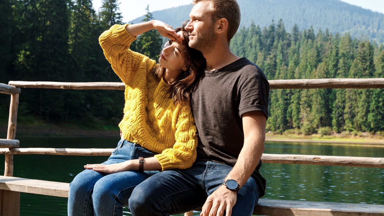 A photo of a romantic couple sitting together enjoying peaceful scenic view deeply connected.