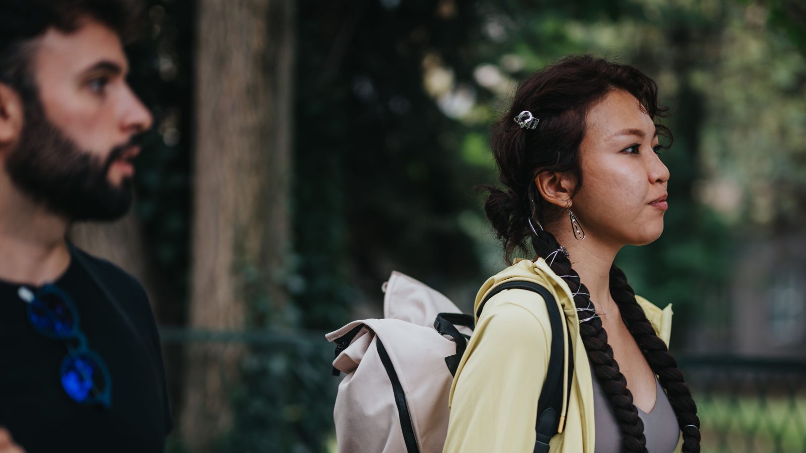 A photo of couple walking in city one slightly ahead other slower subtle tension.