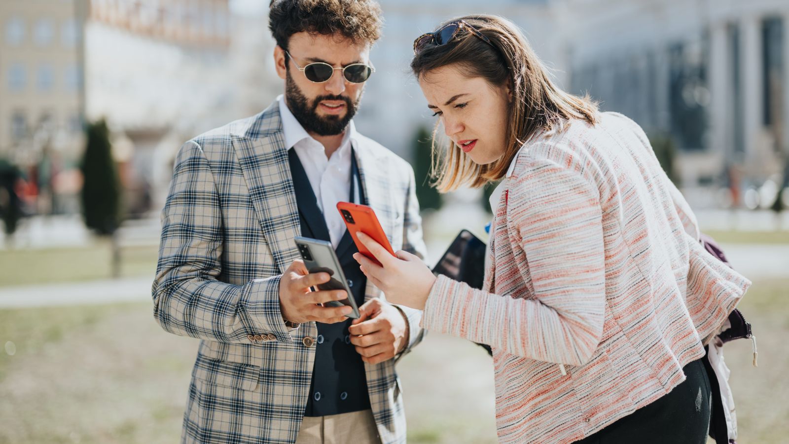A photo of a romantic couple in scenic location but looking at phone or schedule distracted rushed travel moment missed connection candid realistic.