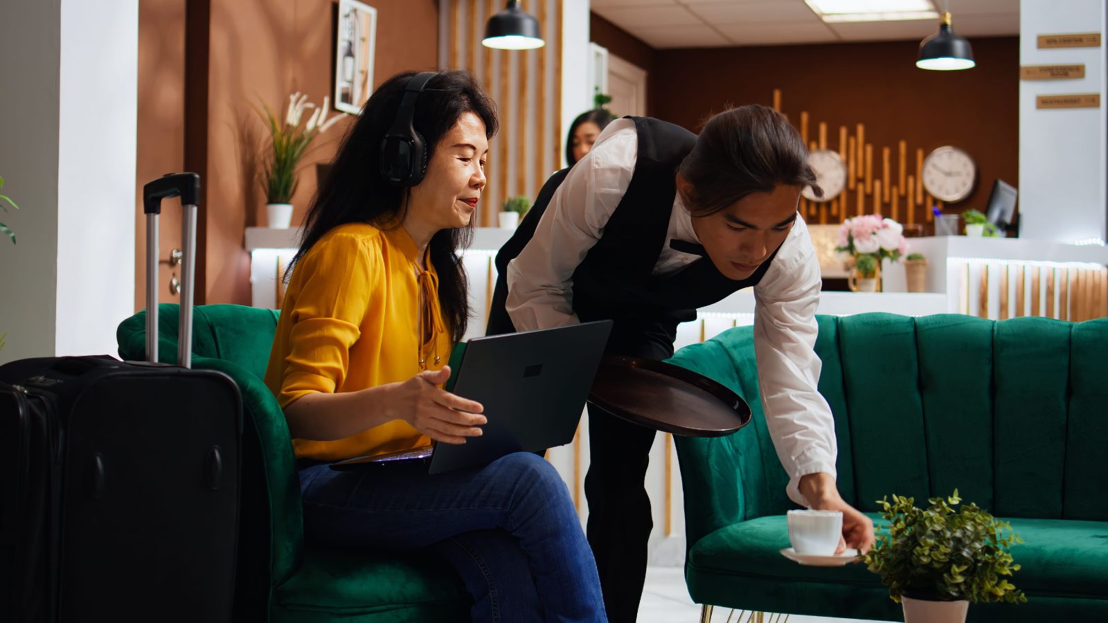 A photo that shows a traveler asking hotel staff for recommendations friendly conversation front desk engaged service interaction candid.