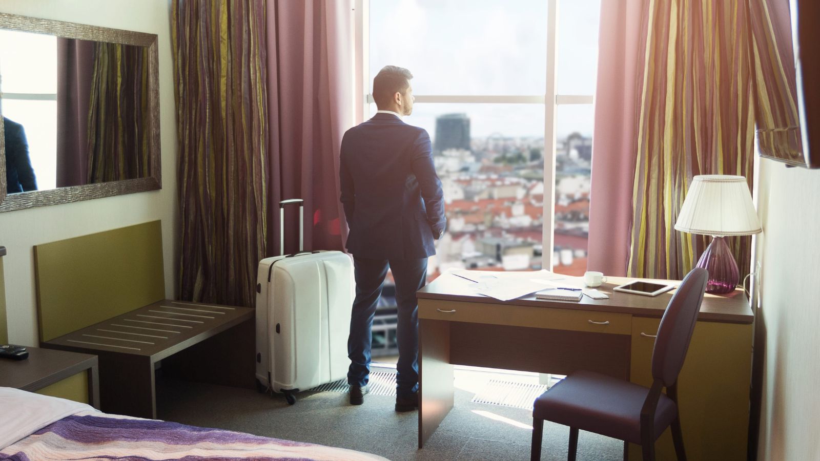A photo of a hotel room near busy street or hallway showing noise disturbance uncomfortable stay travel fatigue realistic candid.