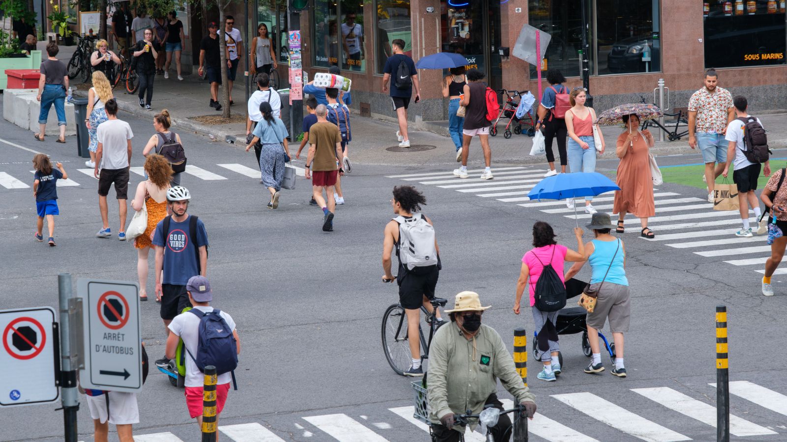 A photo showing tourists walking comfortably along a clean Canadian city street with public transit and friendly locals nearby.