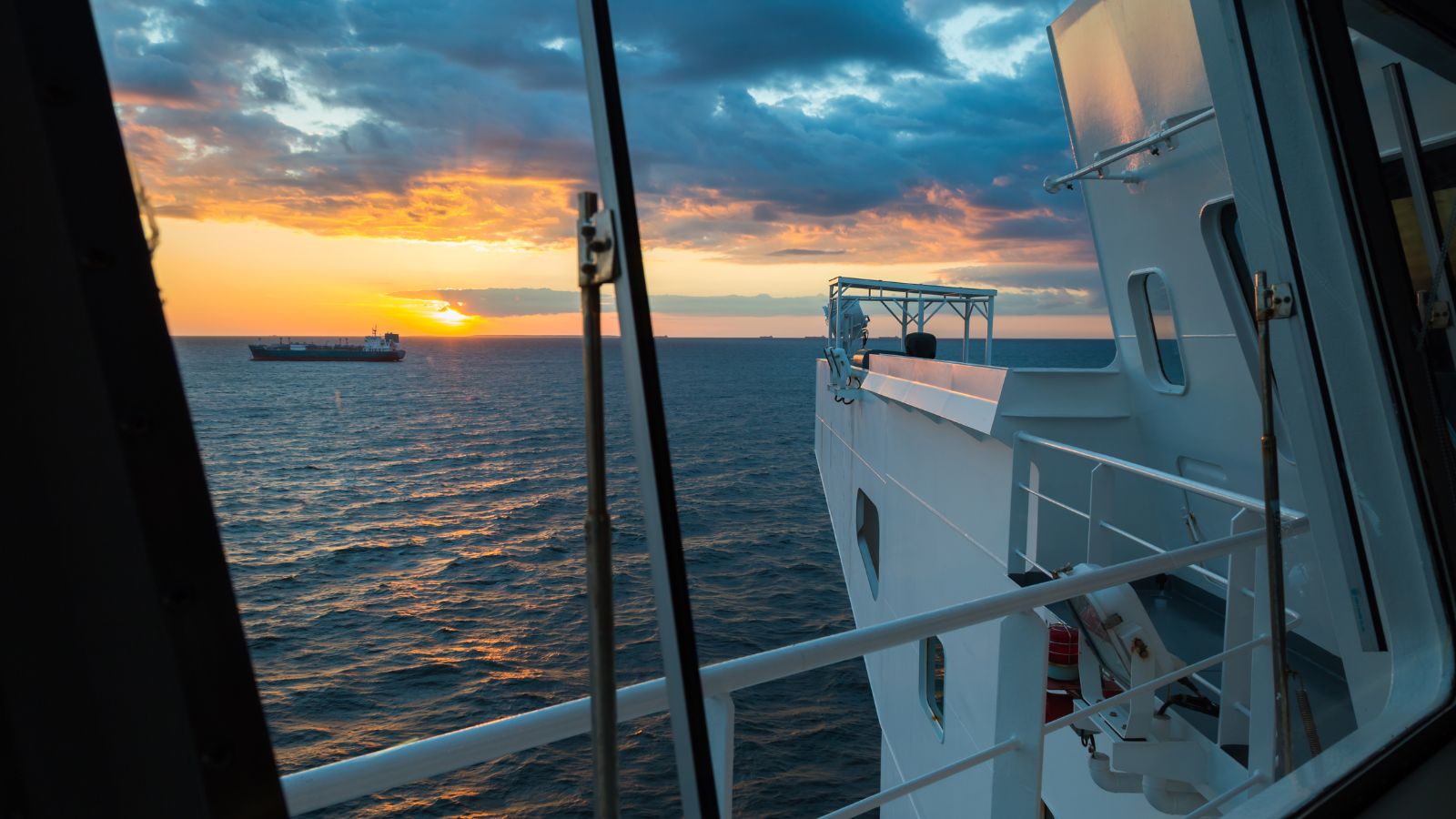 A photo of calm midship cabin balcony view over open ocean at sunset peaceful sea horizon.