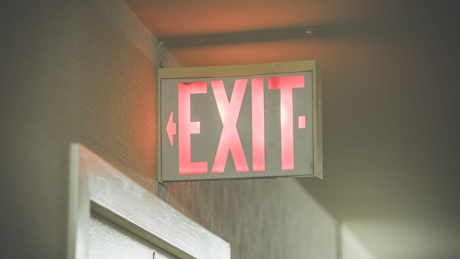 A photo of hotel stairwell with illuminated exit signs descending multiple floors.