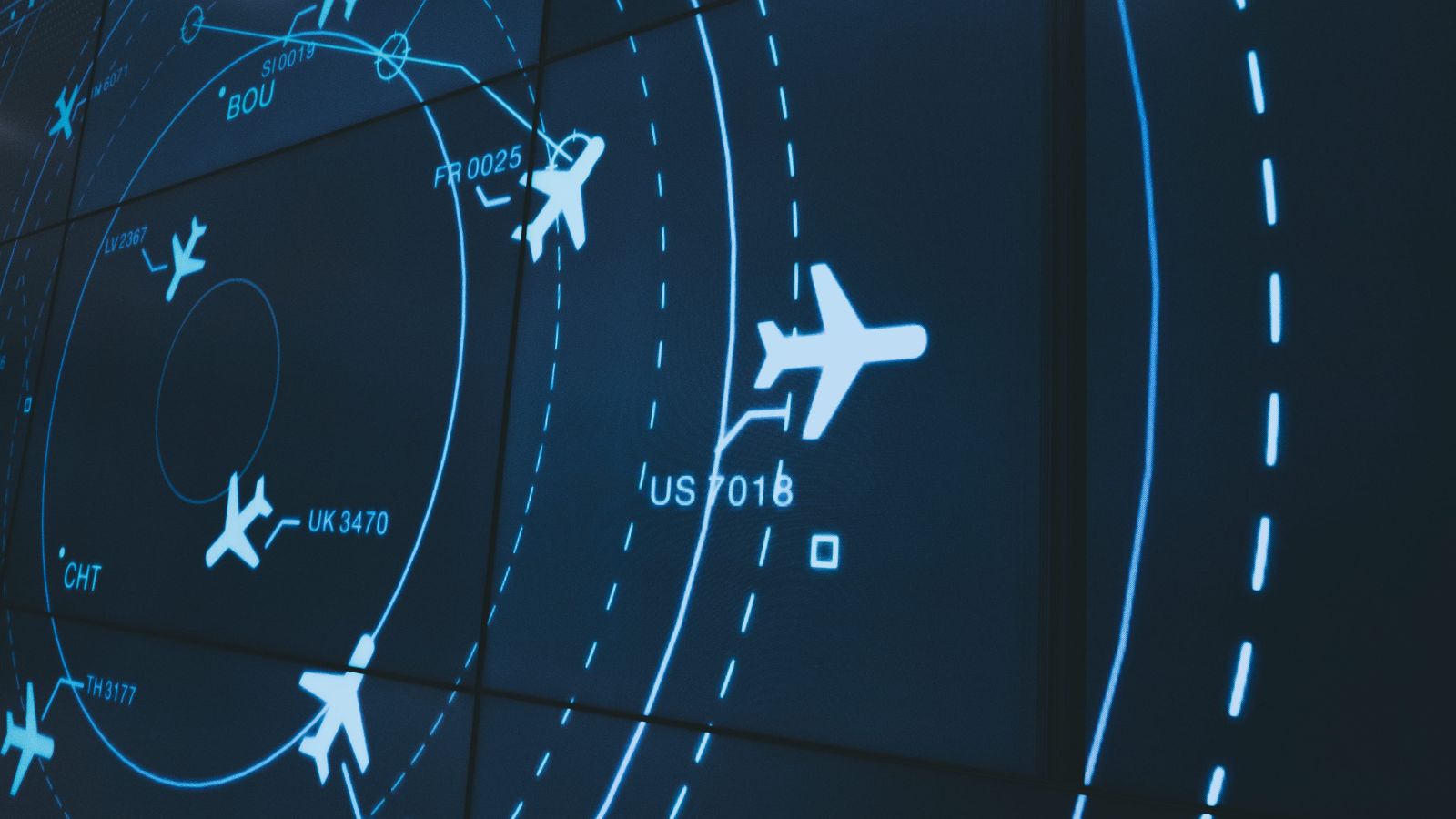 Aircraft icons, flight paths, and identifiers appear with circular route markers on a dark digital display.