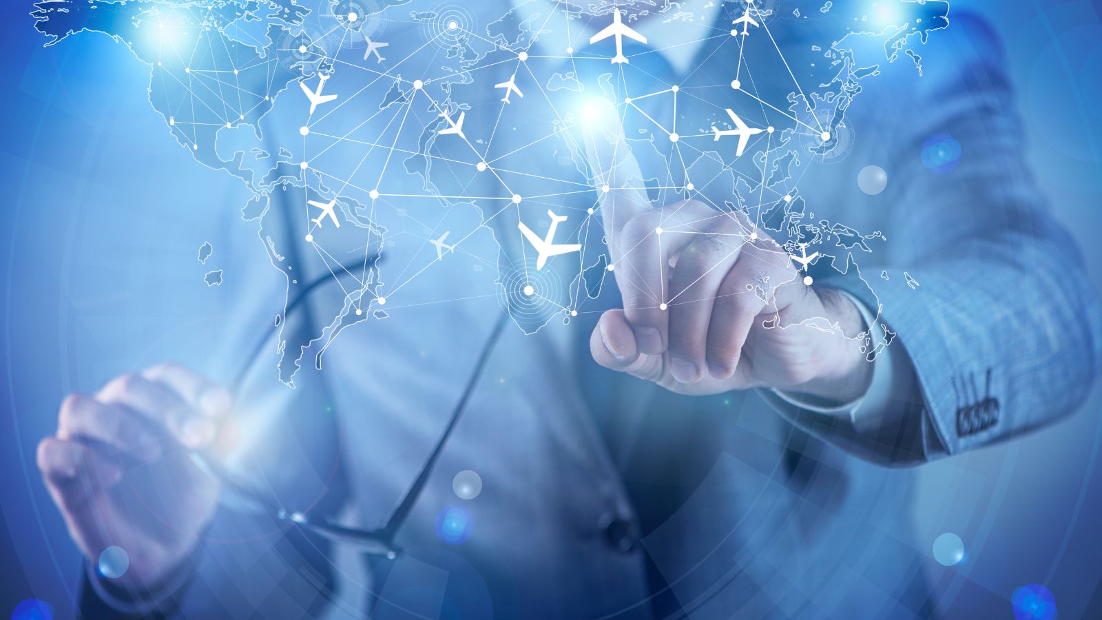 A suited person points at a digital map featuring linked airplane icons, symbolizing global air travel and connectivity.