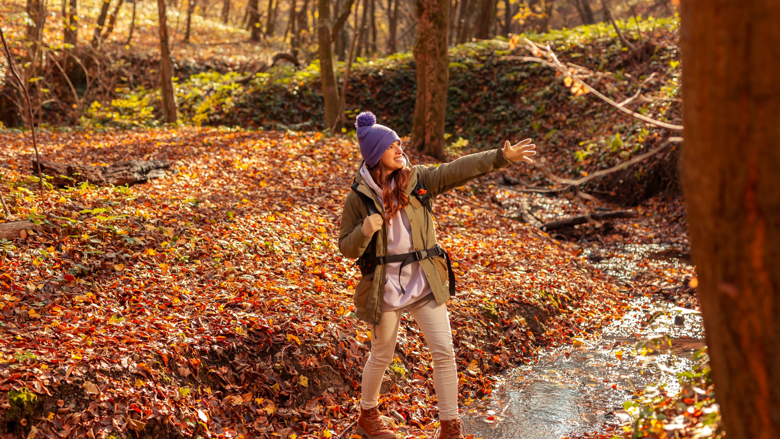 A photo of a happy traveler exploring a Canadian park wearing layered clothing and comfortable walking shoes.