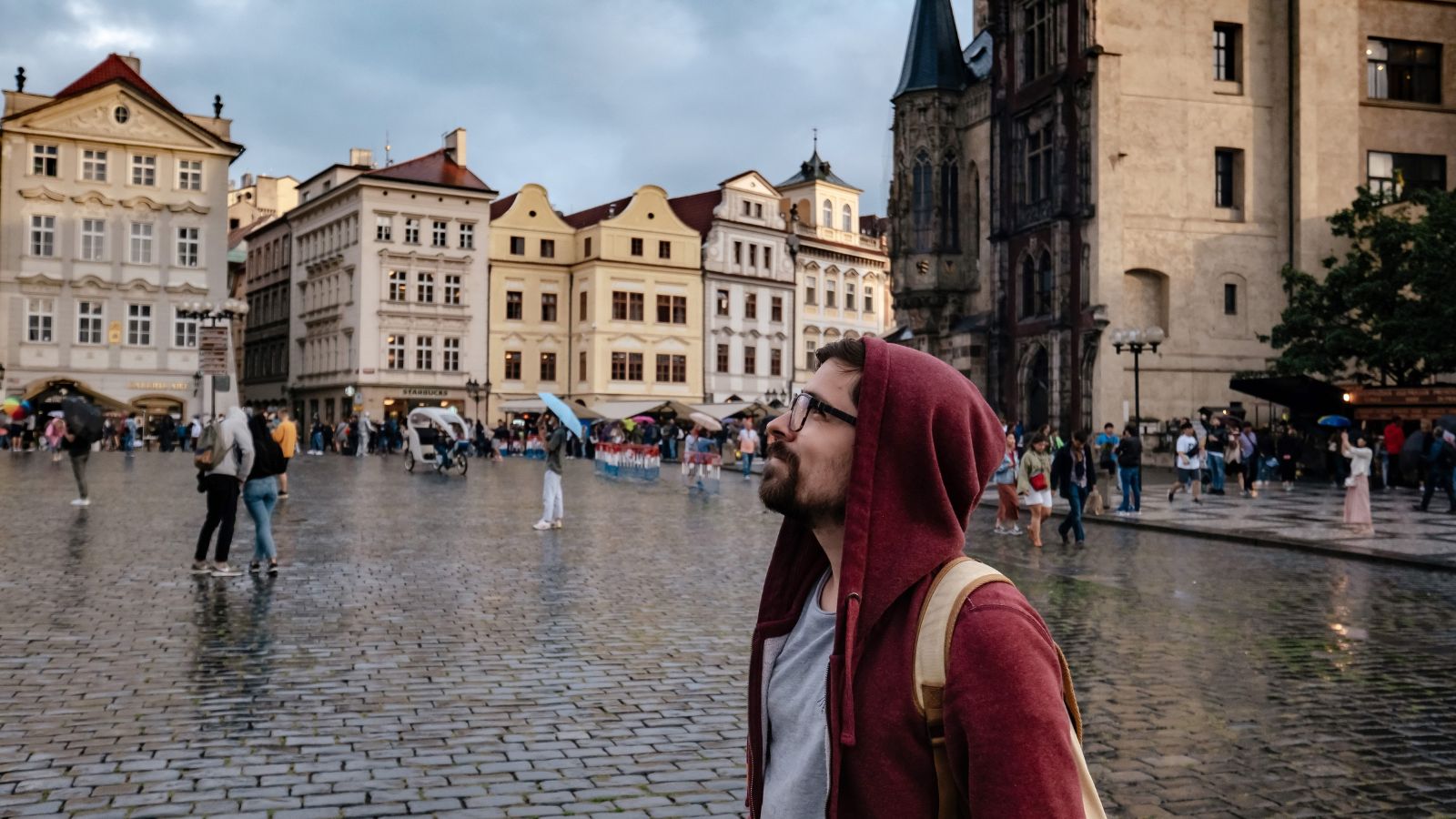 A photo of a traveler walking through a historic European square surrounded by old architecture and classic buildings.