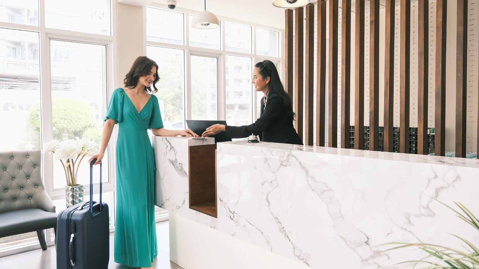A photo showing hotel check in desk with receptionist handing key card modern lobby interior