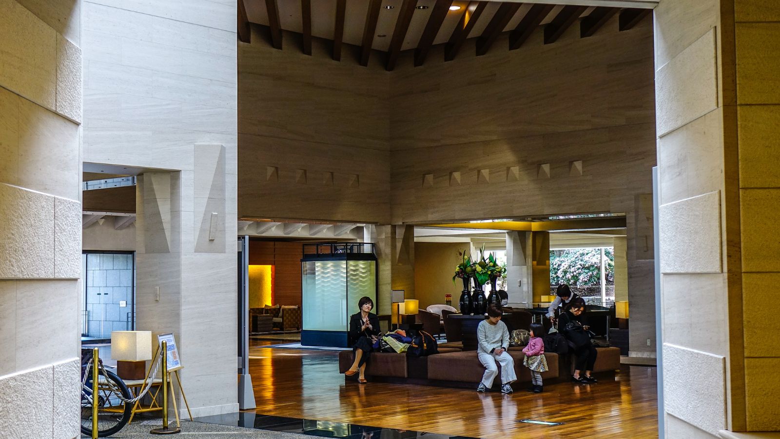 A photo of high floor hotel hallway near executive lounge with guests walking and elevator activity.