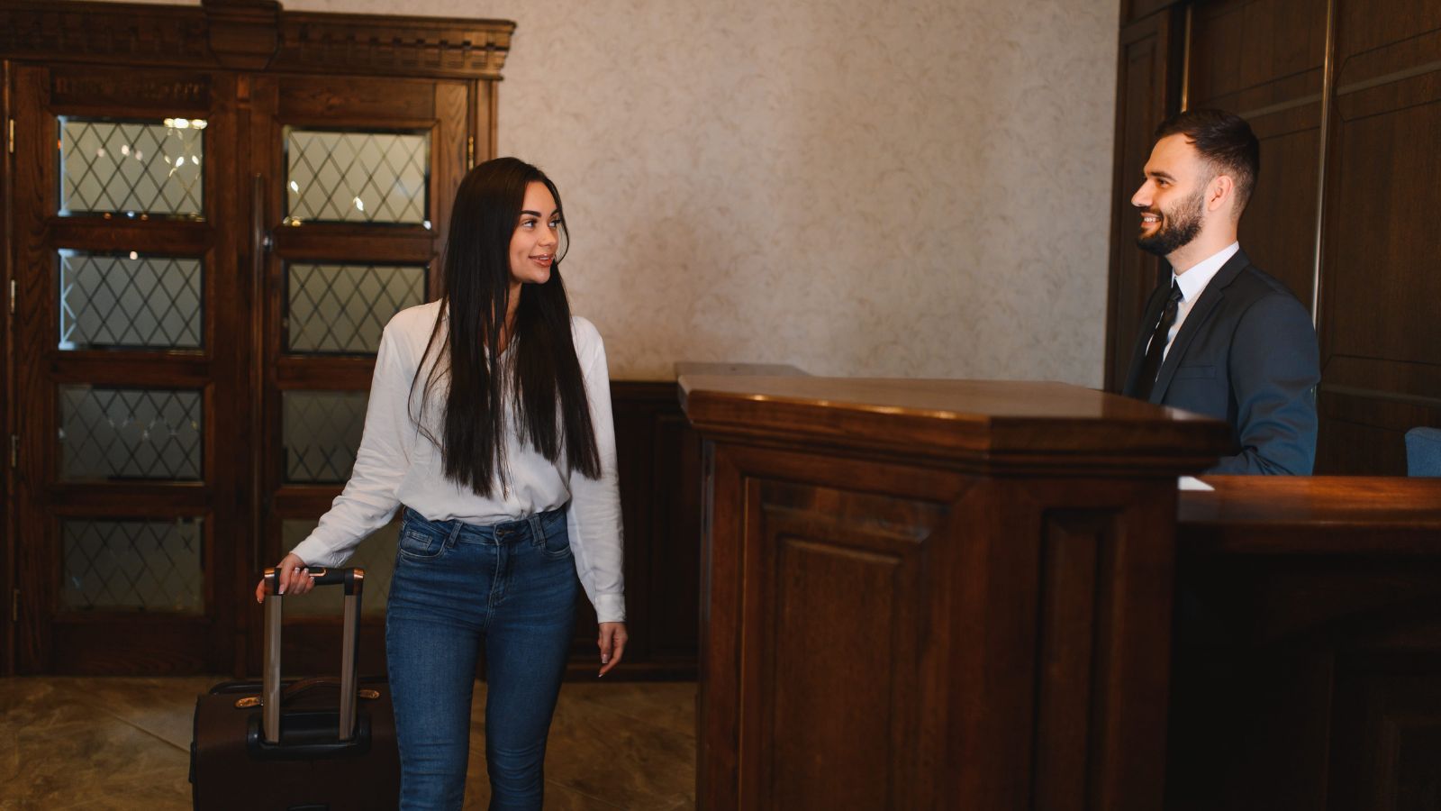 A photo of a woman talking nicely to the receptionist.