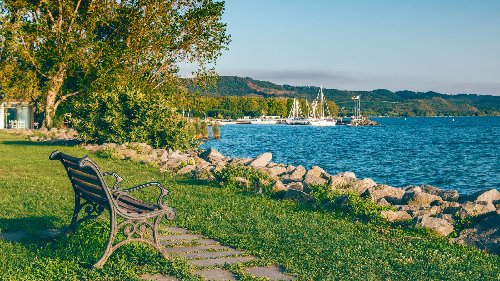 A photo of peaceful Canadian waterfront at sunset with people walking along path relaxed travel atmosphere.