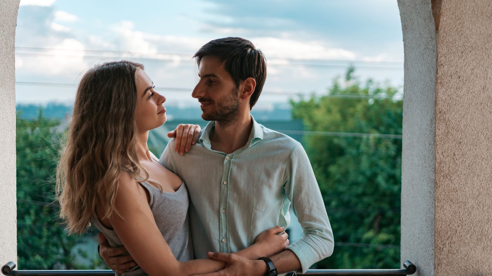 A photo of romantic couple relaxing together scenic view sunset or cozy hotel balcony calm intimate moment restful travel experience natural light.
