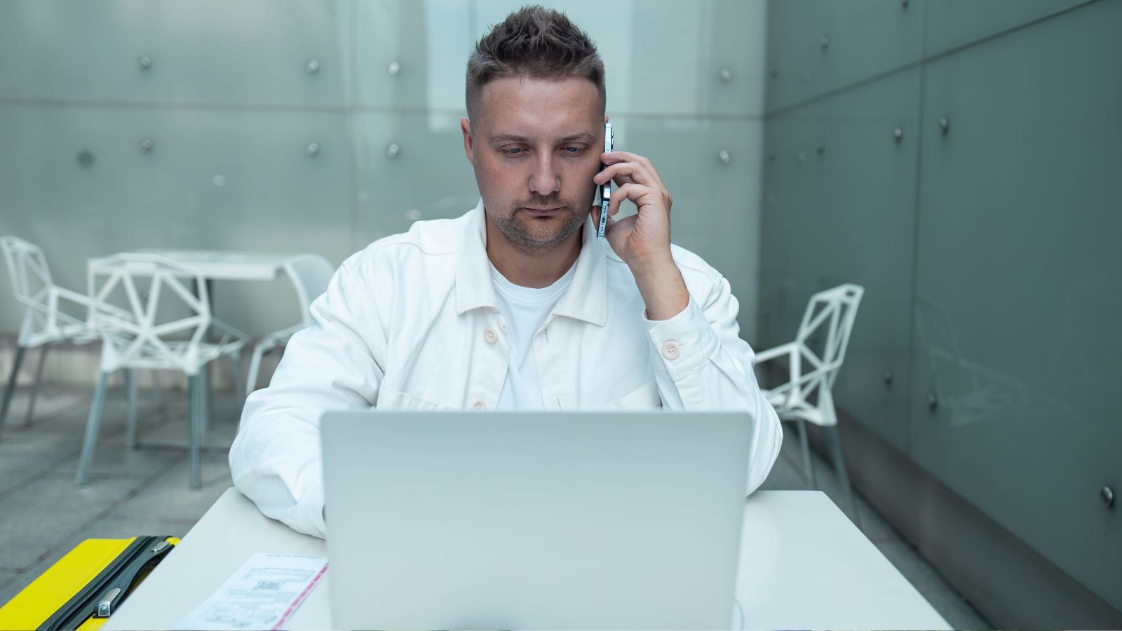 A photo of traveler looking at hotel upgrade options on phone or laptop thoughtful unsure decision making luxury travel.
