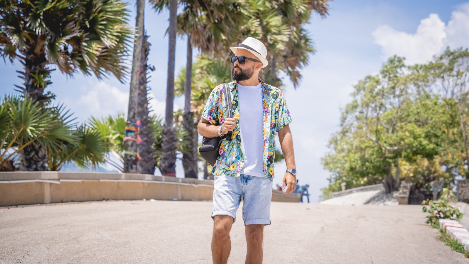 A photo of a traveler walking slowly in quiet coastal town or peaceful street relaxed atmosphere open space minimal crowds.