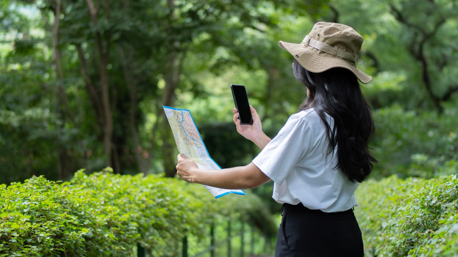 A photo of a woman looking at her phone and map.