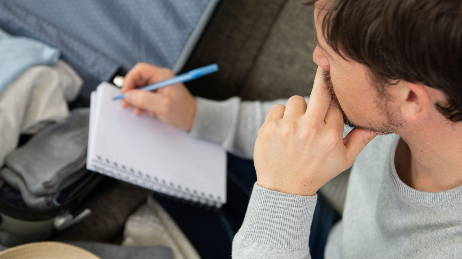 A photo of traveler planning trip checking calendar and travel dates on laptop or phone thoughtful focused decision making.