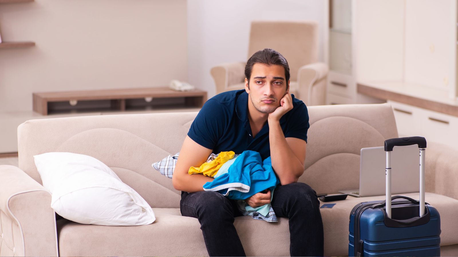 A photo showing a traveler sitting in hotel lobby with luggage looking tired waiting for check in after long journey realistic travel moment.