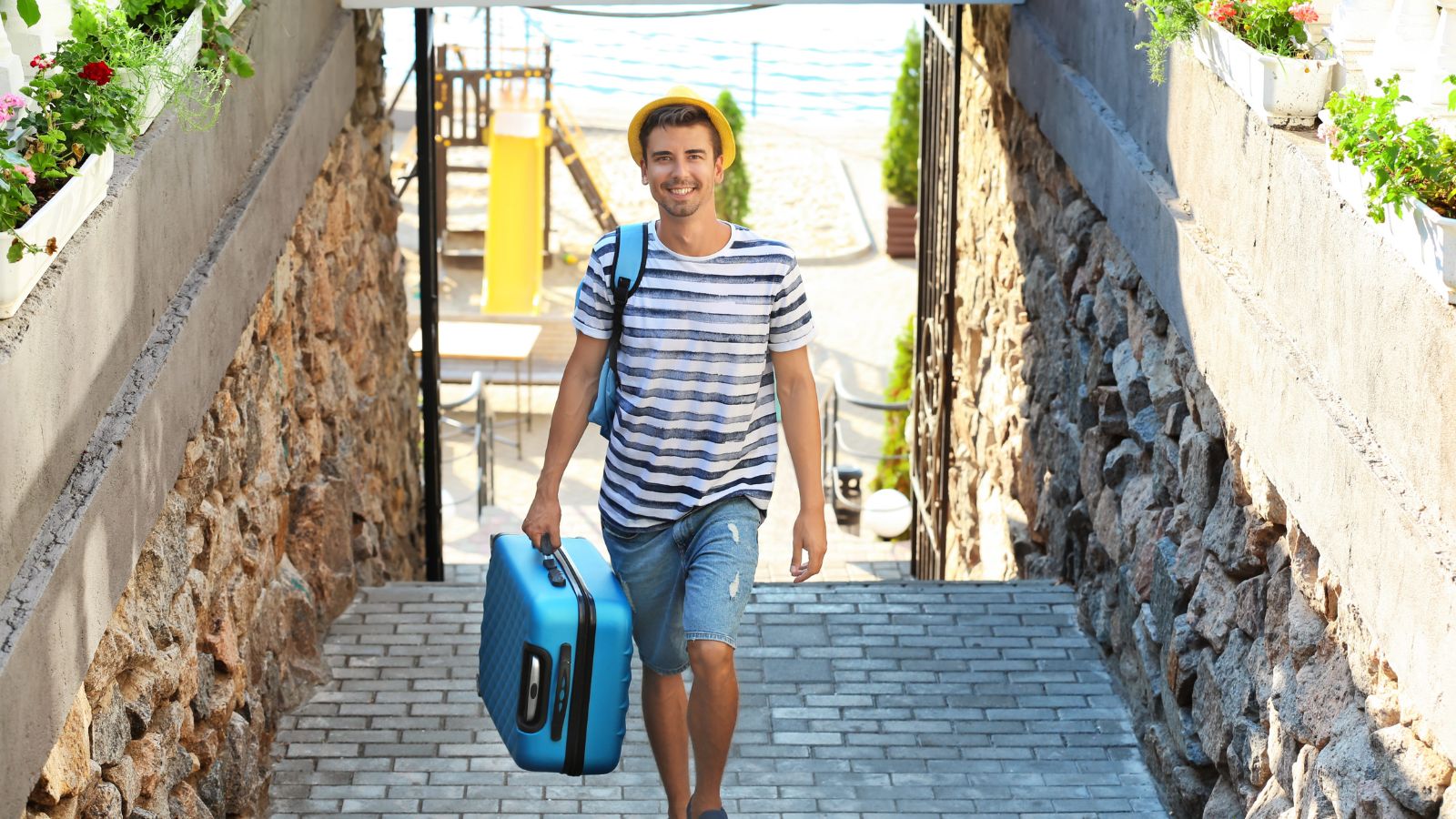 A photo of tourist carrying large suitcase up stairs or cobblestone street struggling travel heavy luggage urban setting candid.