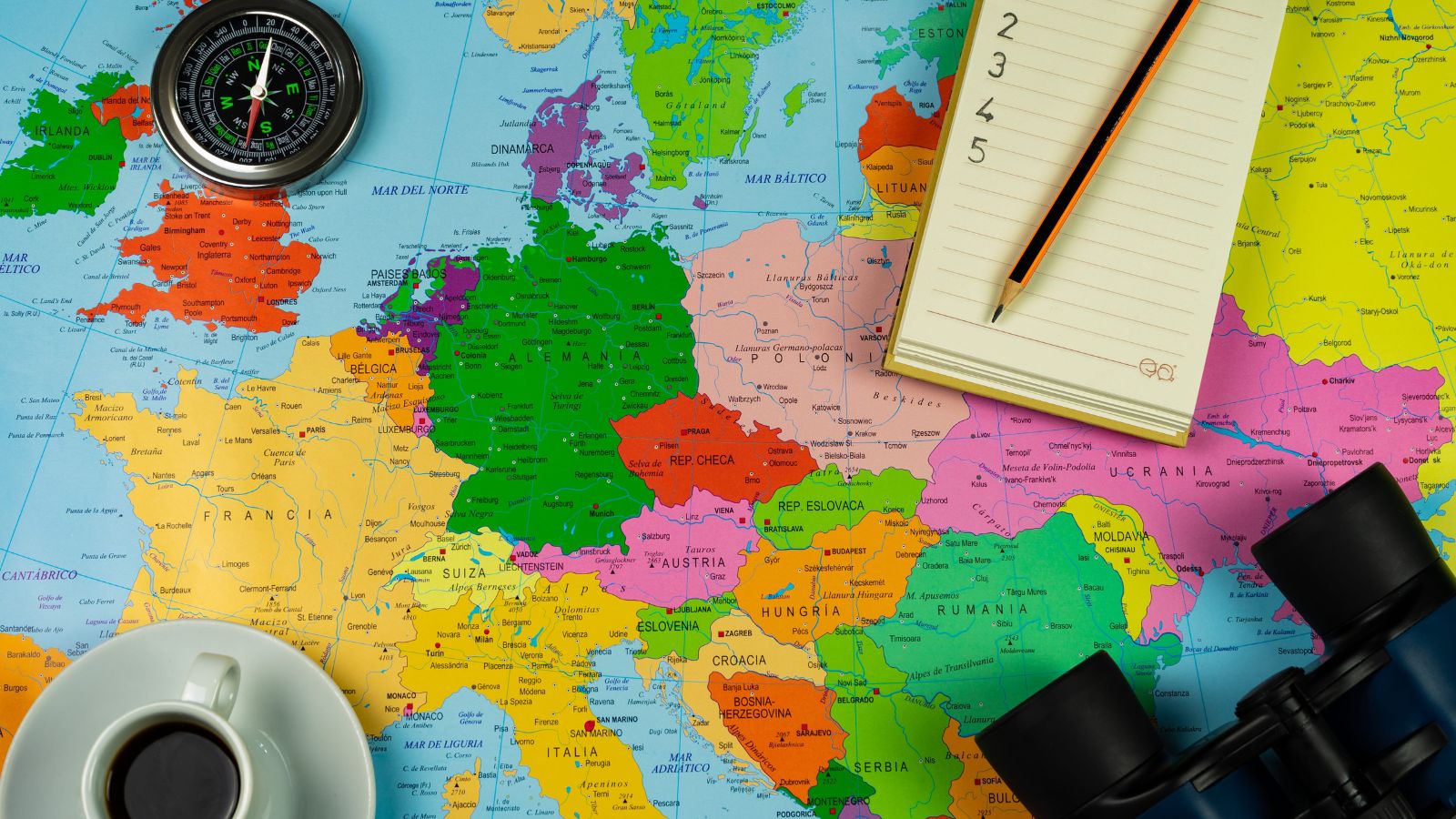 A photo that shows a traveler planning trip with map showing multiple destinations routes many cities itinerary ambitious travel planning flat lay natural light.