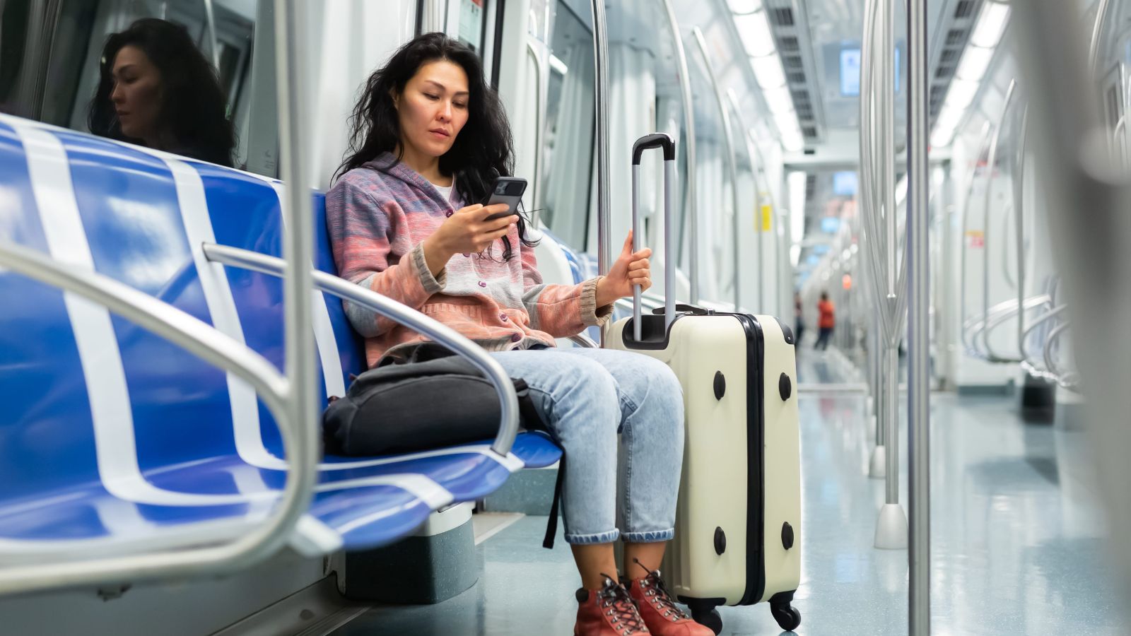 A photo of a traveler riding train or bus with small luggage budget travel public transportation candid realistic.