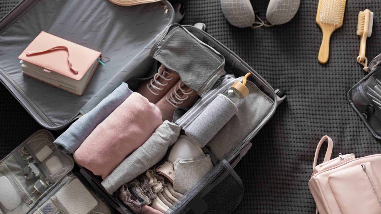 A photo that shows minimalist suitcase neatly organized neutral clothing packing cubes travel efficient packing flat lay.