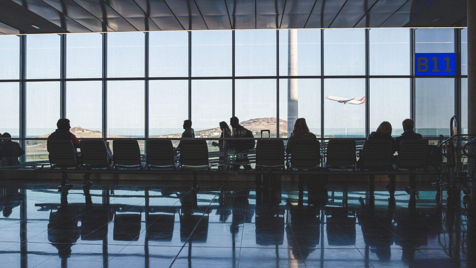 A photo of calm airport terminal seating area early morning soft light minimal passengers.