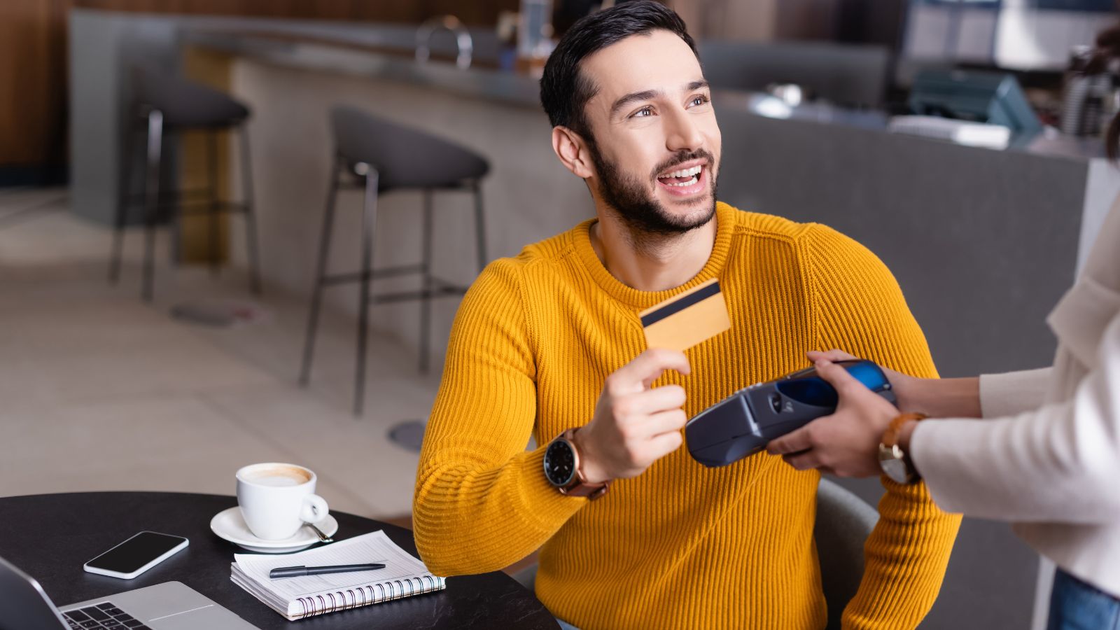 A photo of traveler paying bill at cozy Canadian café with receipt and credit card, realistic travel expenses.