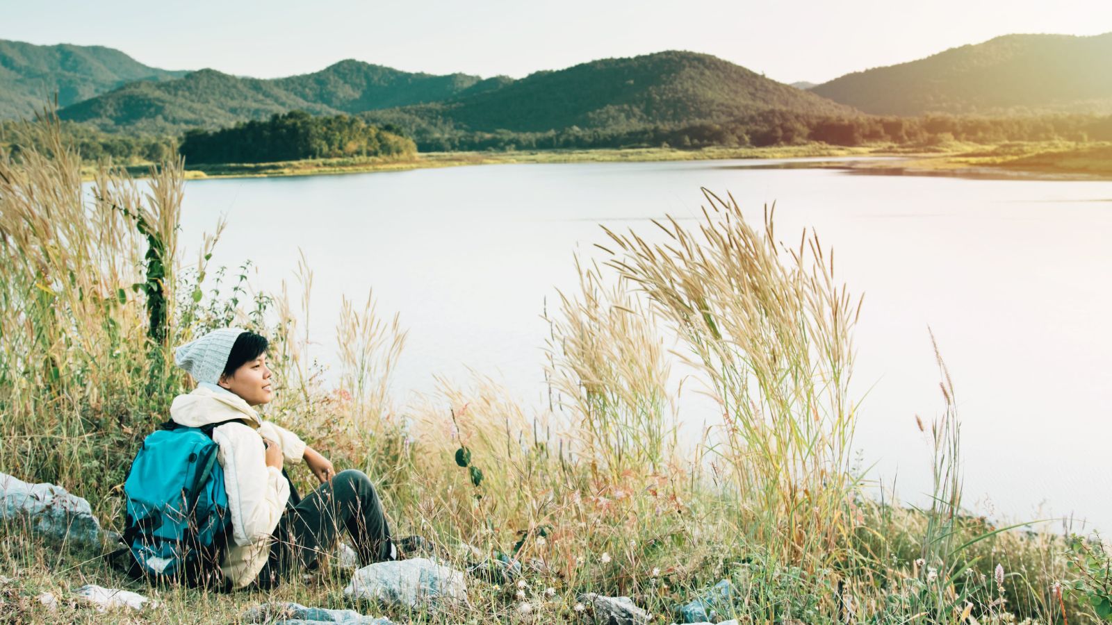 A photo of a traveler enjoying surroundings fully present walking or sitting scenic place no phone slow travel lifestyle natural candid.