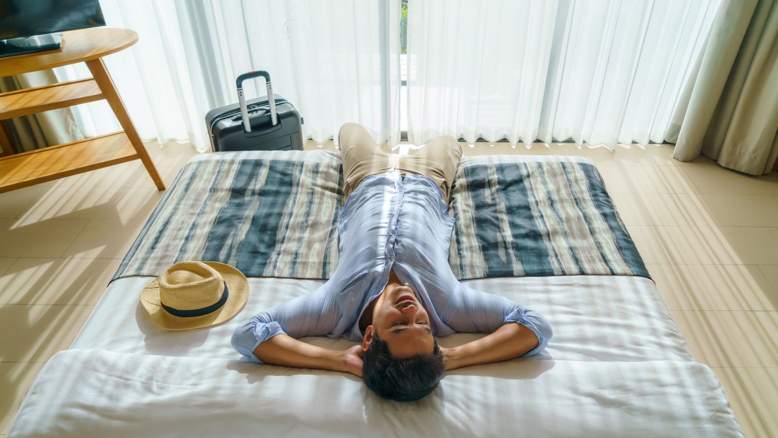 A photo of a peaceful hotel room traveler sleeping comfortably quiet environment soft lighting relaxed travel stay.