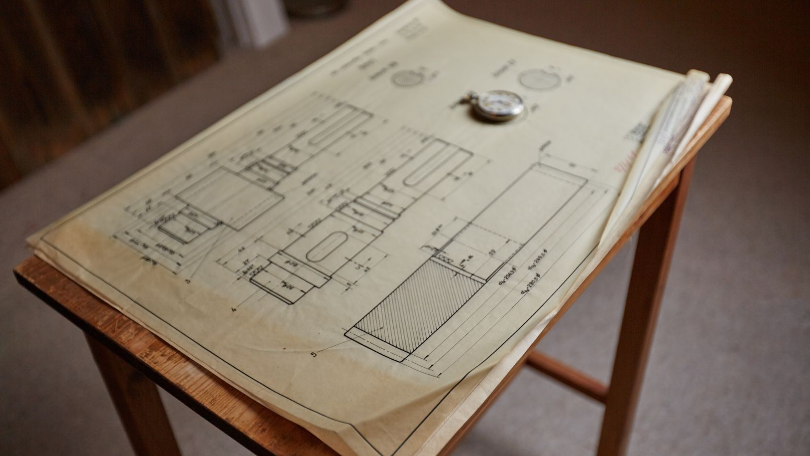 A photo of large cruise ship deck plan blueprint spread across table with cabin locations highlighted.