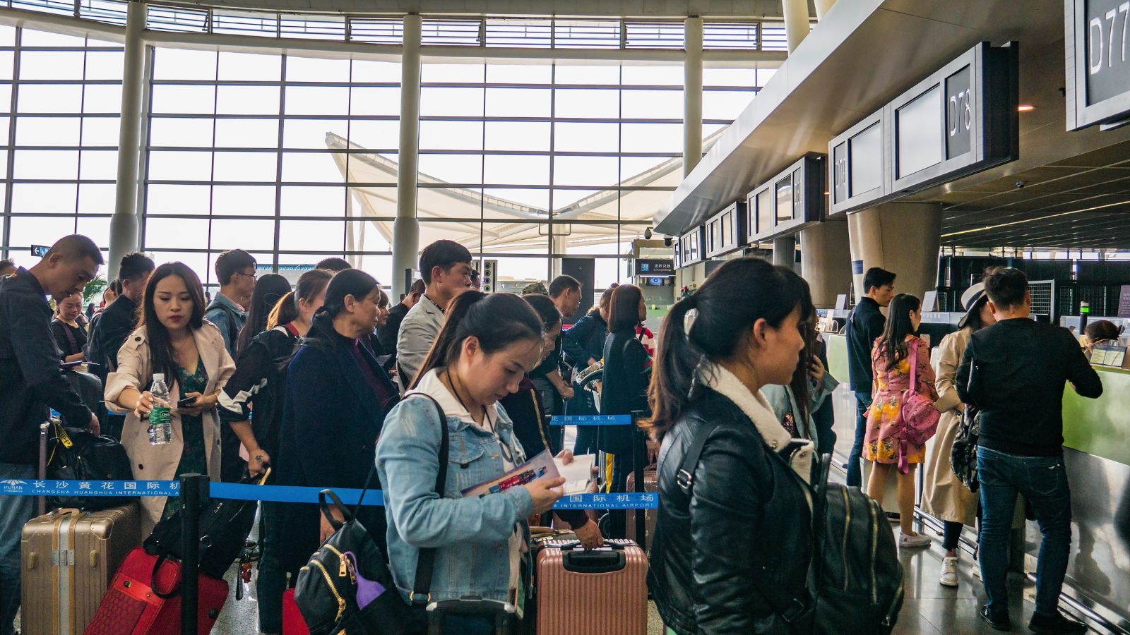 A photo of busy airport security line during peak departure hour crowded terminal.
