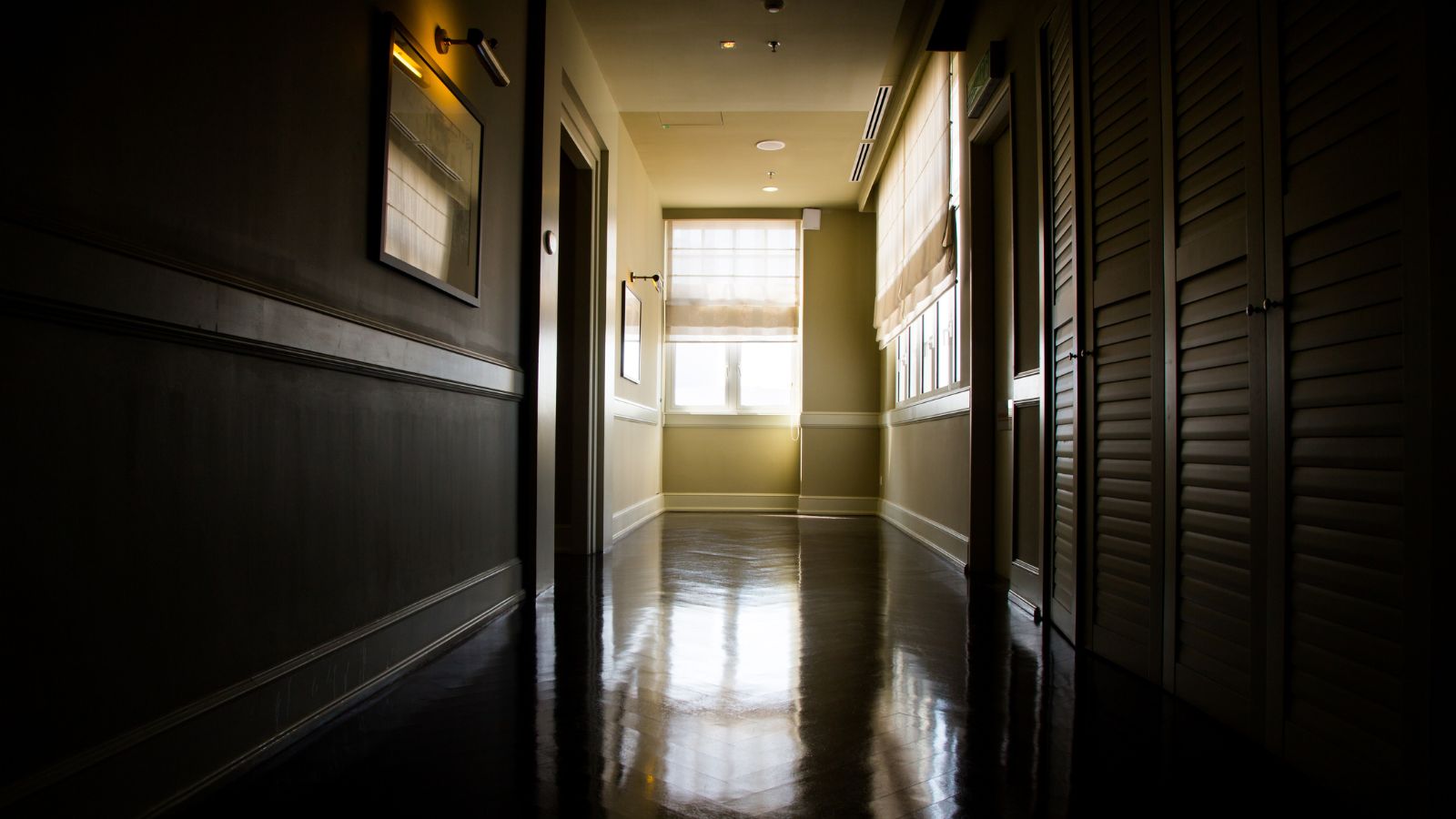 A photo of quiet mid hallway hotel room interior soft lighting no nearby foot traffic peaceful atmosphere.
