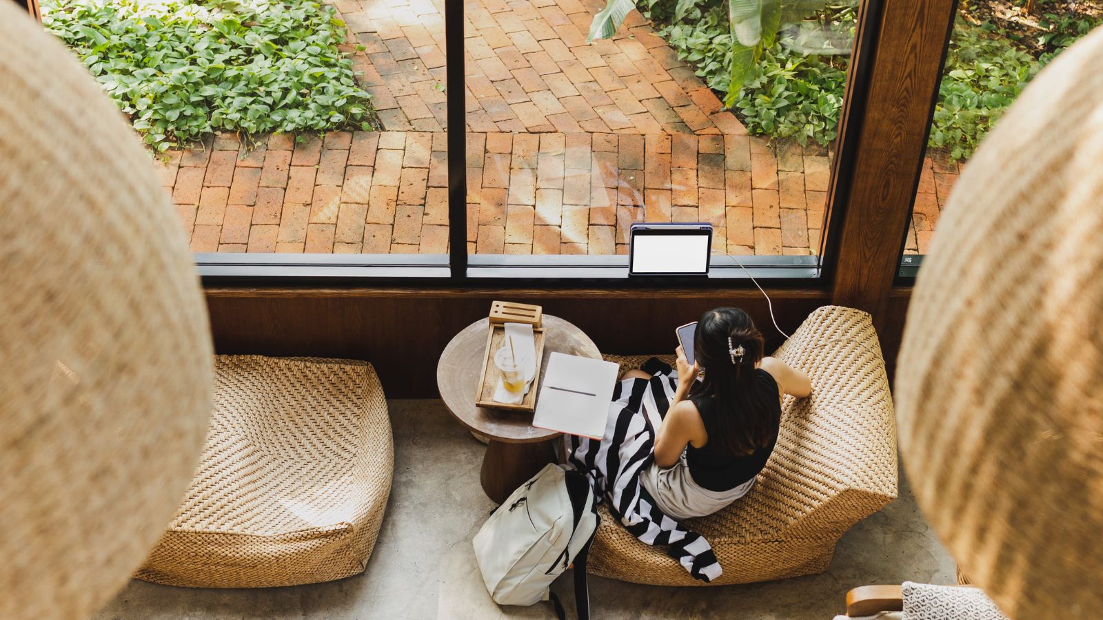 A photo of a traveler relaxing with coffee in a cozy boutique hotel lounge or courtyard, peaceful and welcoming environment.