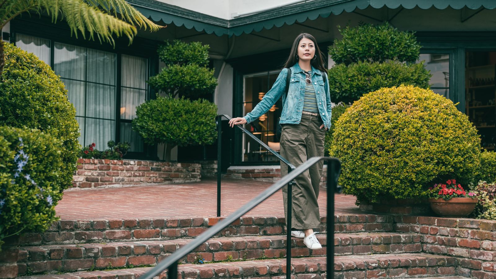 A photo of a traveler arriving at a charming small boutique hotel with a calm and welcoming entrance