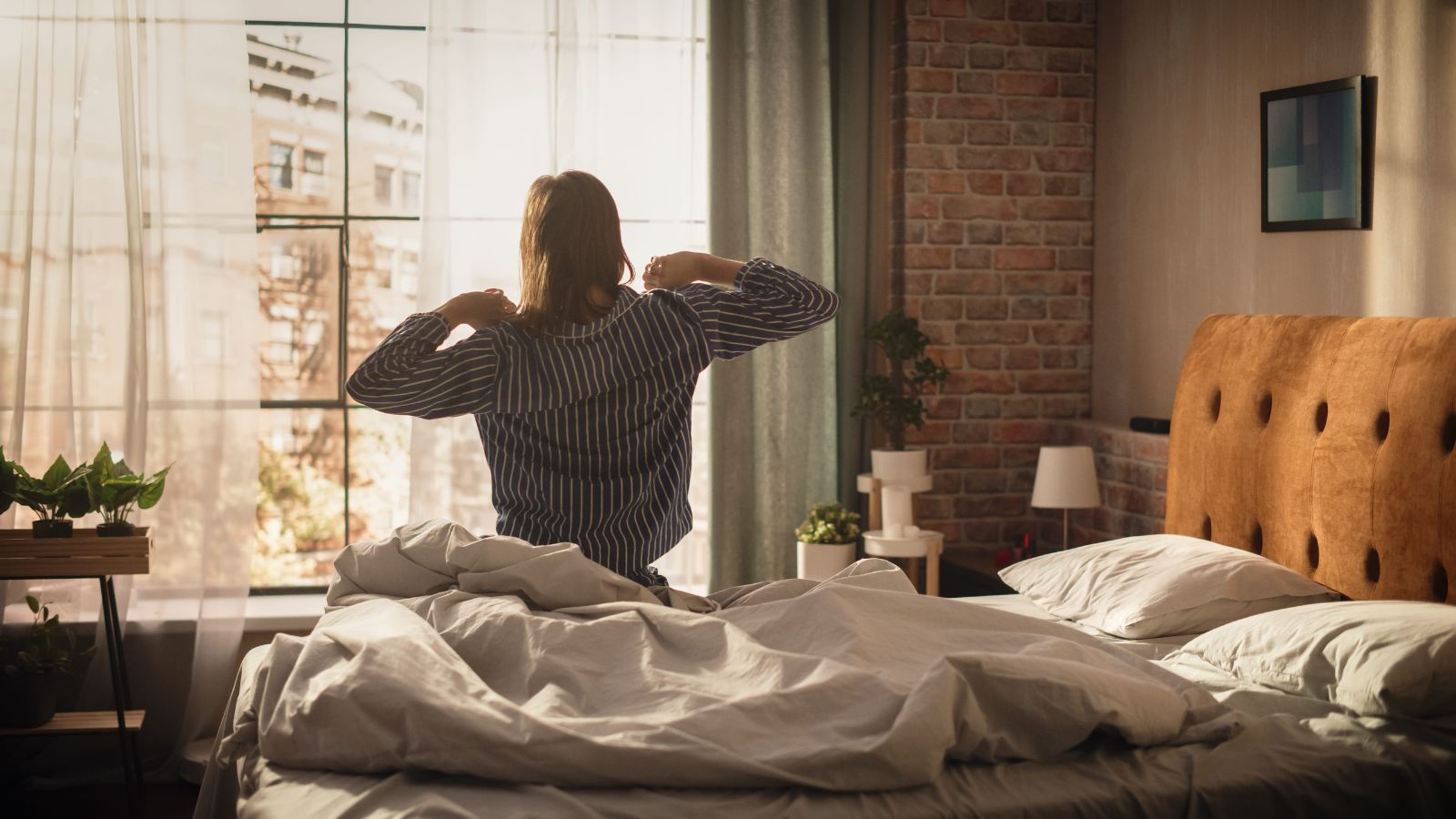 A photo of traveler waking up refreshed in a quiet hotel room with soft morning light coming through the window