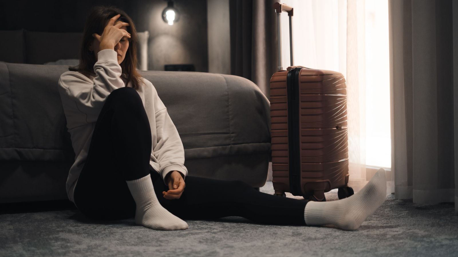 A photo of a tired traveler early morning rushing or late night exhausted in city or hotel travel fatigue long day candid realistic.