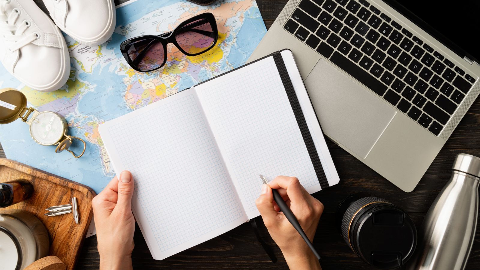 A photo of a travel itinerary notebook or phone schedule fully packed day plan maps tickets organized travel planning flat lay.