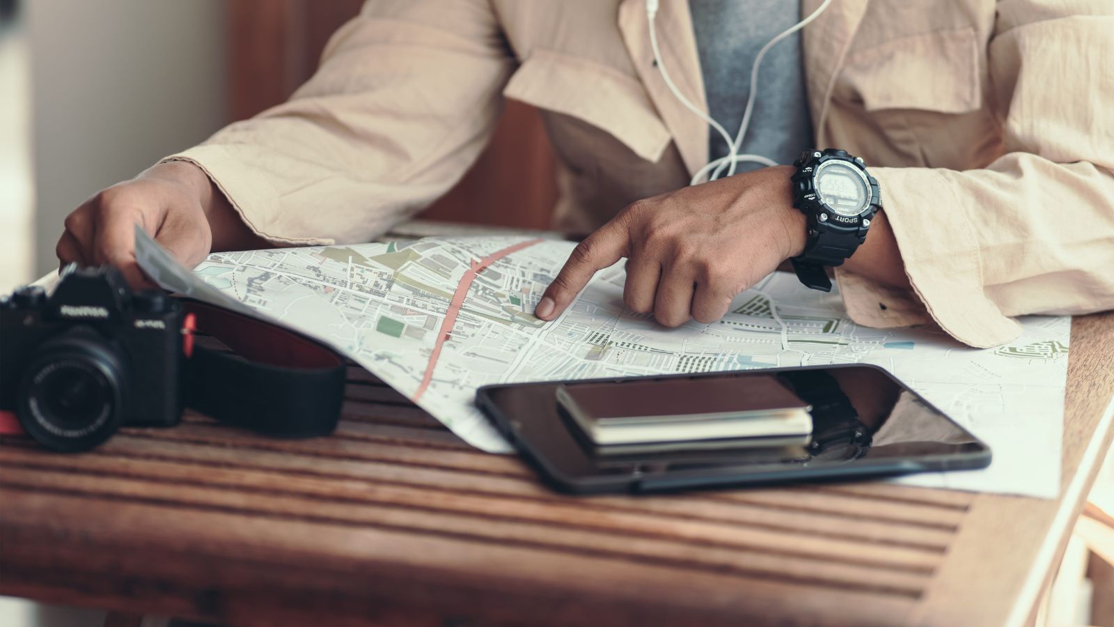 A photo of a traveler looking at full travel itinerary or maps feeling overwhelmed planning trip busy schedule flat lay.
