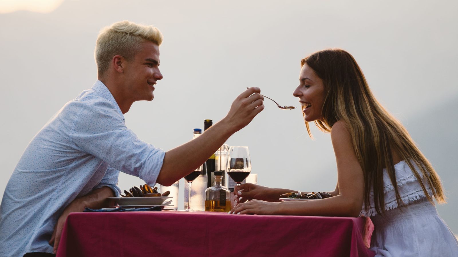 A photo of romantic couple enjoying peaceful moment together, outdoor dinner or sunset view, intimate and relaxed, connection and joy, lifestyle travel photography, natural light, candid.