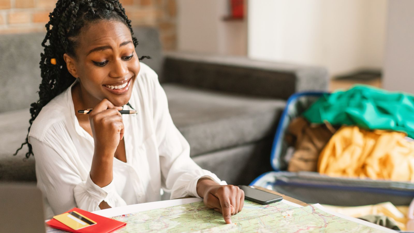 A photo of a woman, smiling thinking deeply looking at the map.