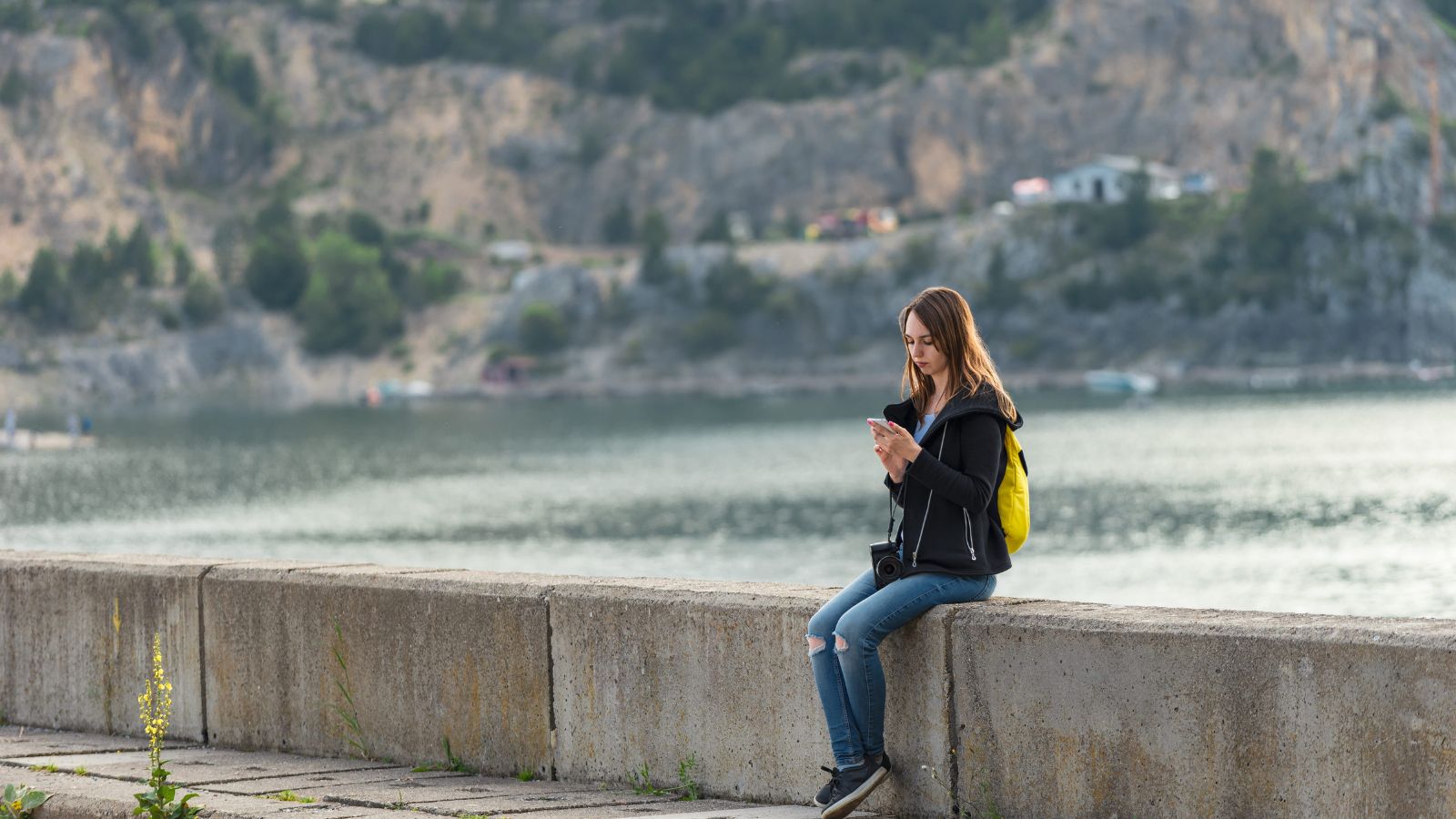 A photo of a woman, facing phone.