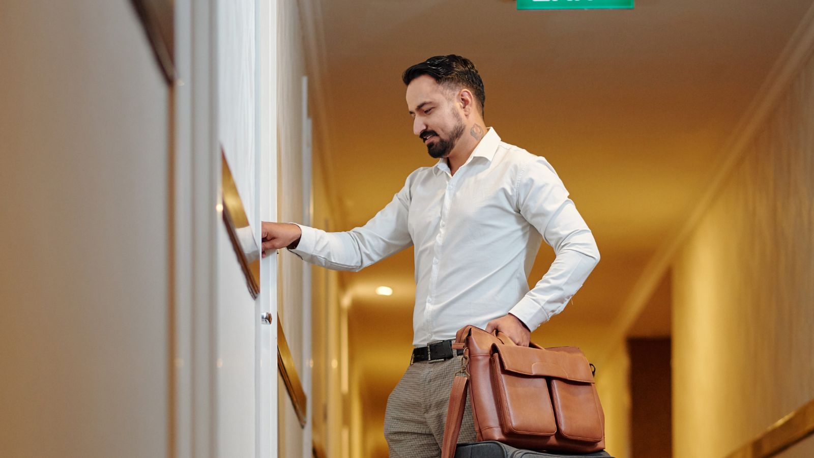 A photo of a man, thinking carefully before entering a room.