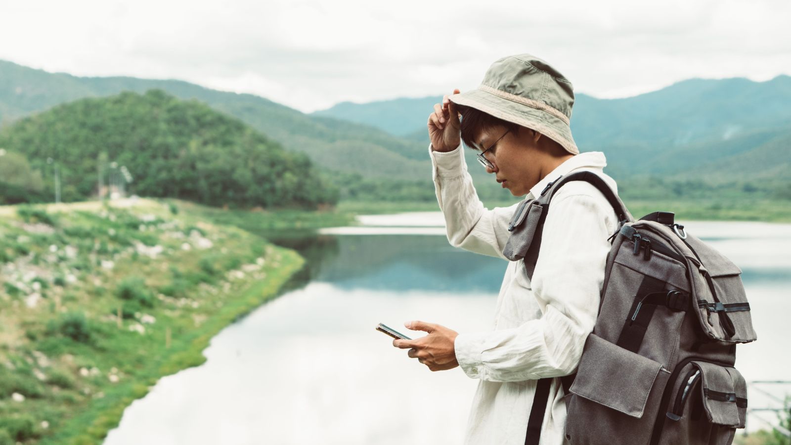 A photo of a traveler at airport or outdoor location reacting to delay or change looking slightly frustrated adjusting plans.