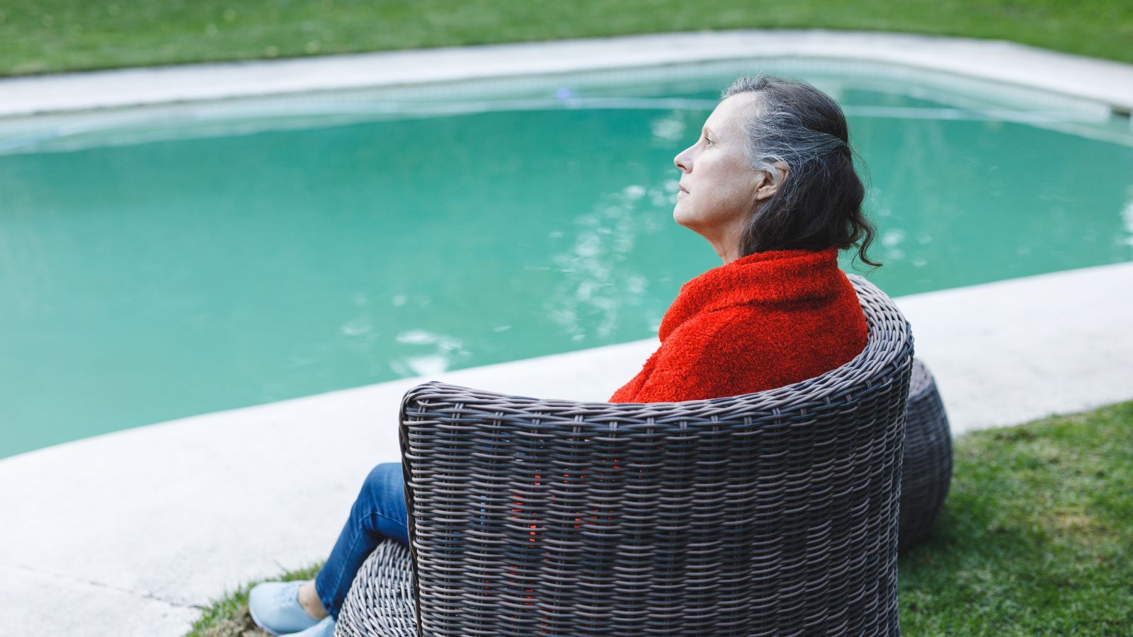 A photo of a traveler relaxing in a peaceful boutique hotel courtyard or lounge, enjoying a calm and welcoming environment.