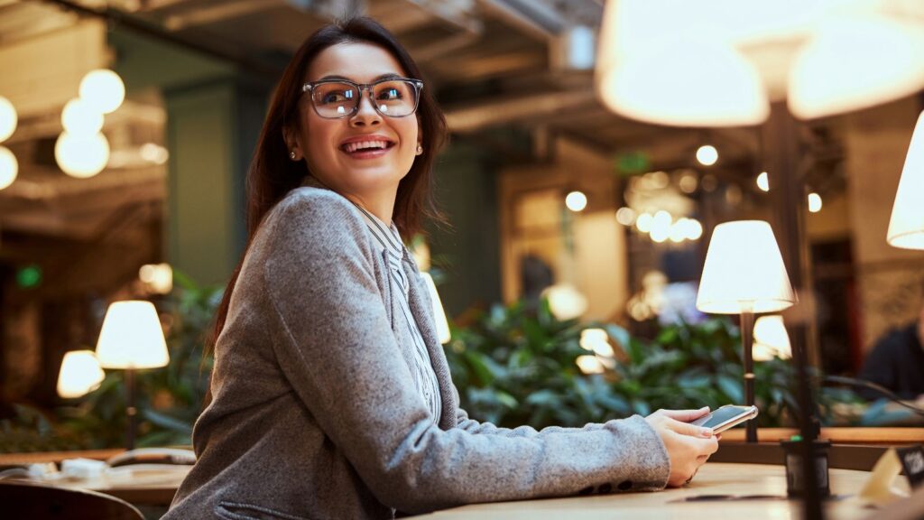 A photo of a woman sitting and smiling from a table