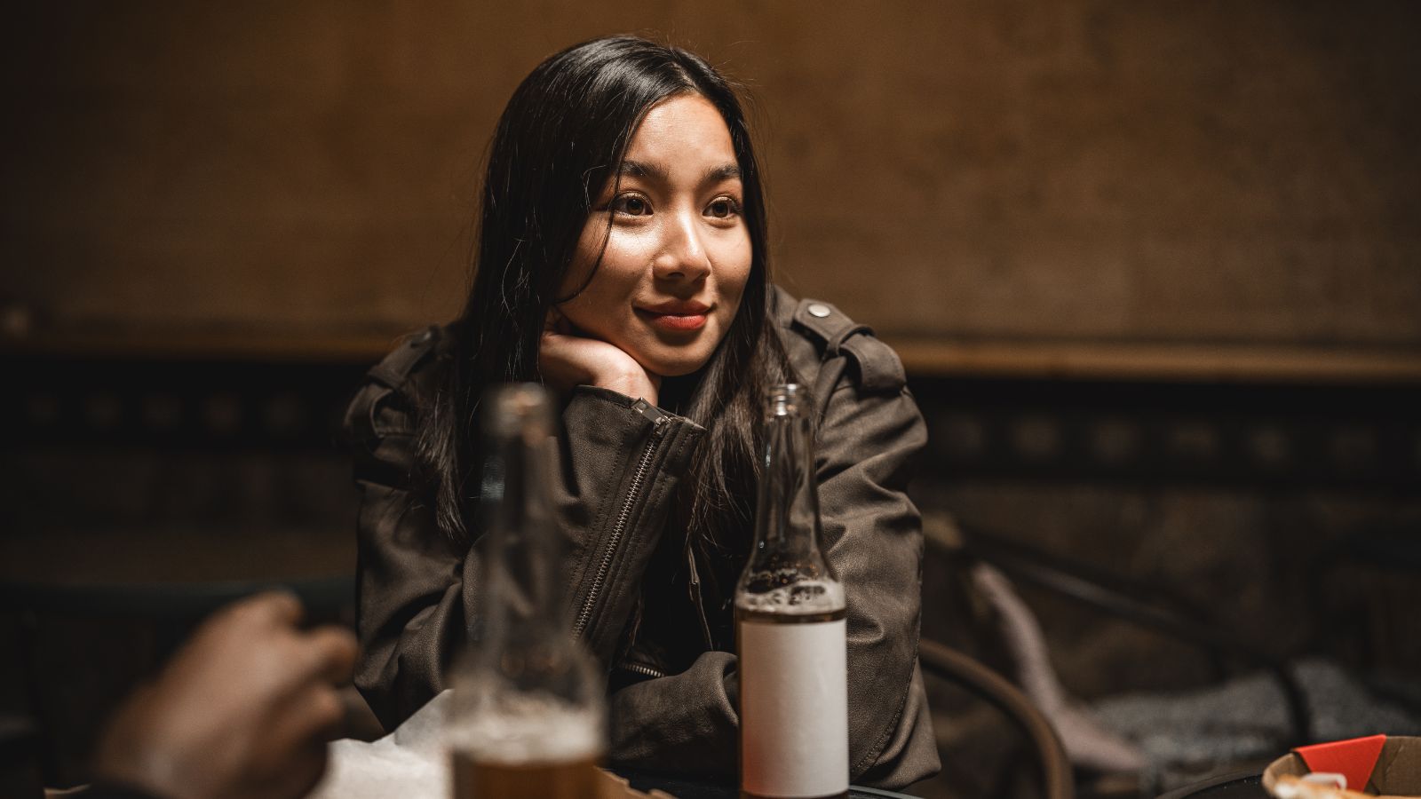 A photo of a traveler sitting at a cozy restaurant on the first night of a trip, warm lighting and relaxed travel atmosphere.